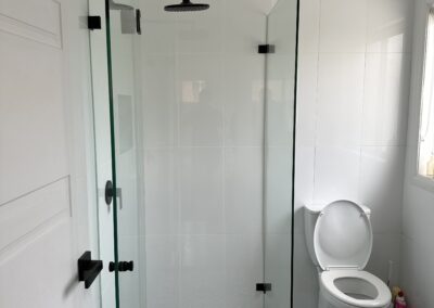 Completed shower repair in Sydney, new floor tiles, wall tiles and glass shower doors completed with new black hardware.