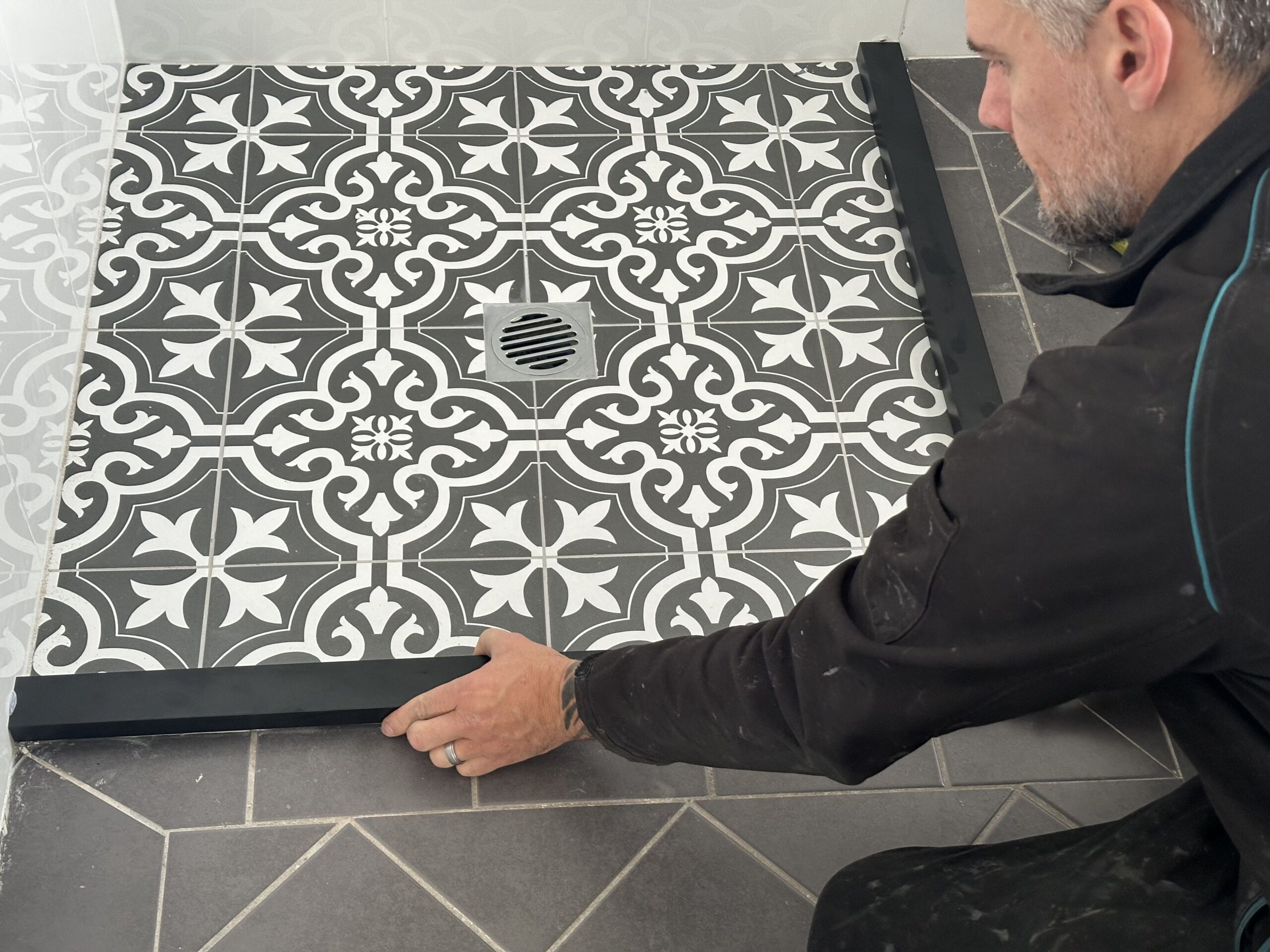 The team working on a shower repair in Sydney, fitting new floor tiles.
